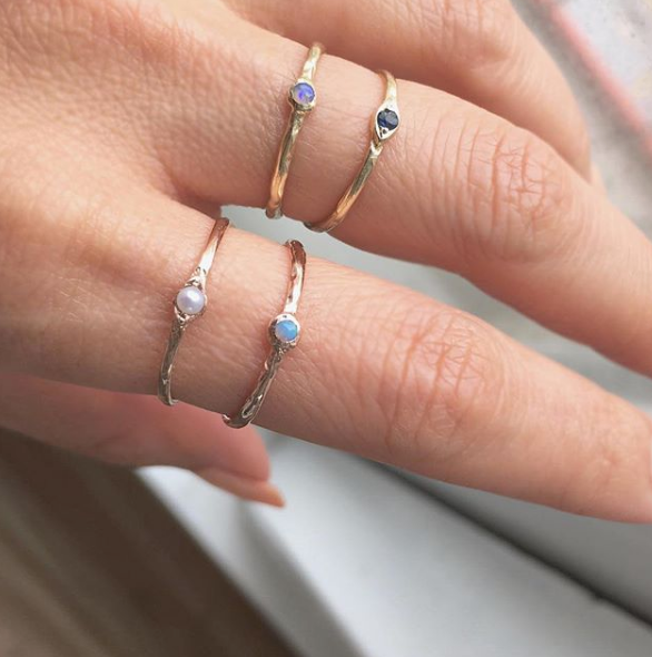 2 Sets of 14K Yellow Gold Rings with gemstones on woman's hand.