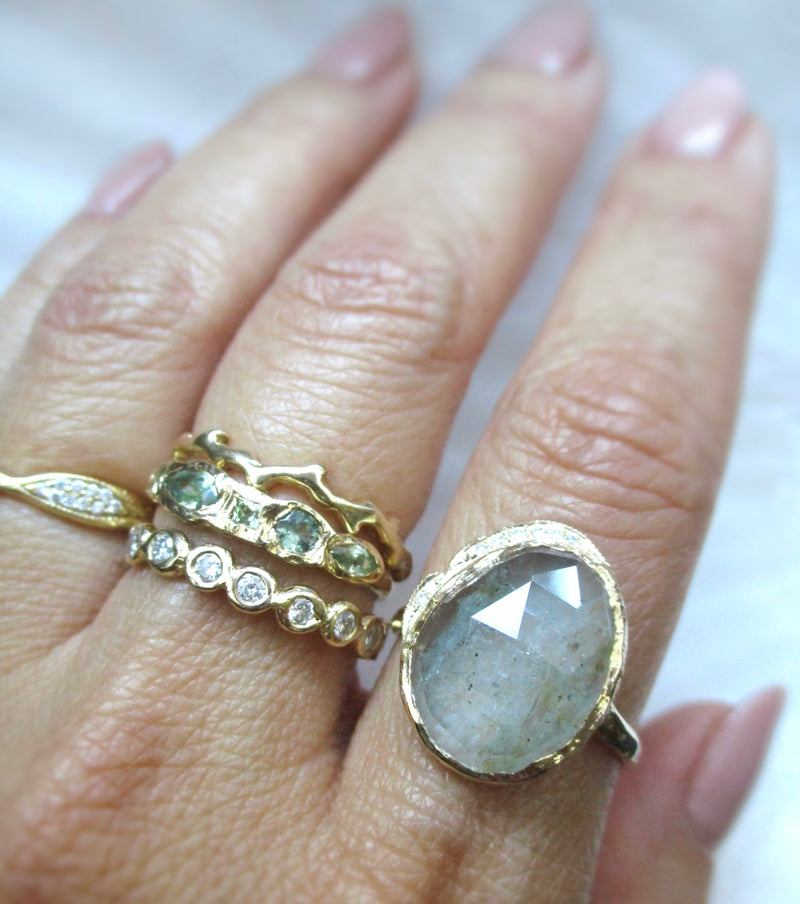 14K yellow gold rings with aquamarine, green sapphires and diamonds on the hand