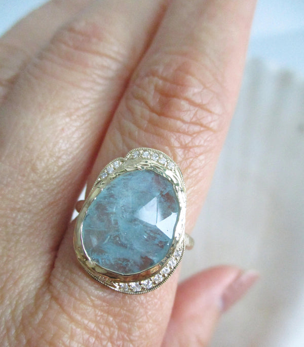 Handcrafted 14K yellow gold aquamarine ring with white diamonds on the hand