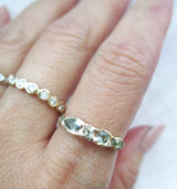 14K gold green sapphire ring on the hand against a white background