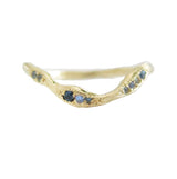 Gold ring with embedded blue gemstones on a white background