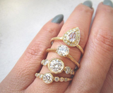 4 gold diamond rings on woman's hand