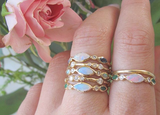 4 Aurora Emerald Rings on woman's hand. 