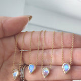 4 14K Compass necklaces with opal on woman's hand.