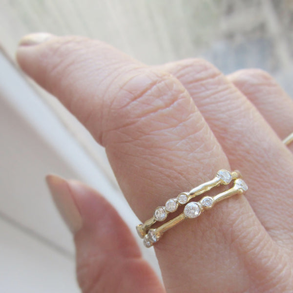 Gold Eternity Ring with diamonds on woman's finger. 