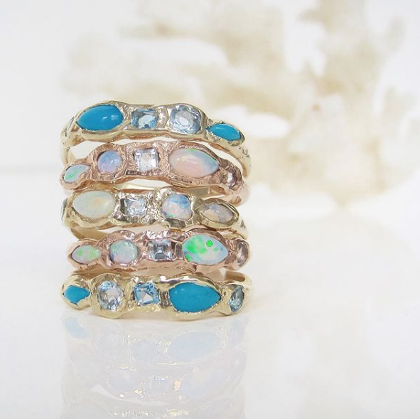 5 staggered 14K yellow gold rings made with opal and aquamarine.