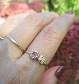 Floret pink sapphire ring with three white round brilliant accent diamonds.