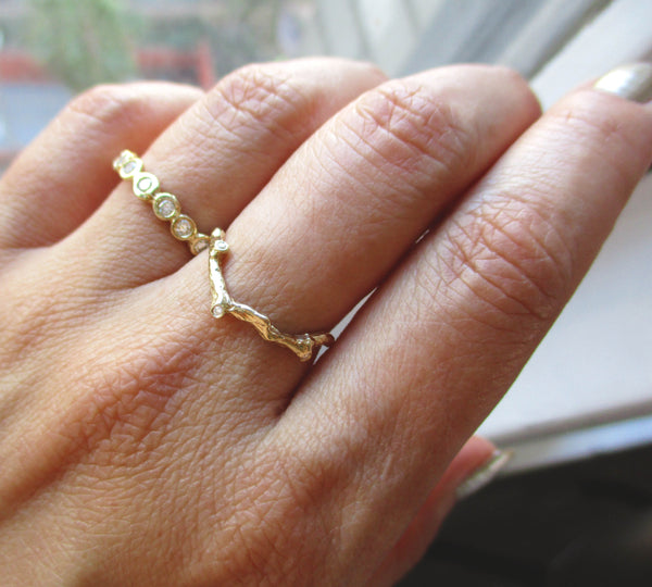Cradle vine ring with white round brilliant diamonds on woman's hand.