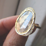 Diamond slice hidden cove ring with white round brilliant small diamonds on Woman's Hand.