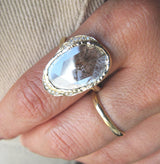 Diamond slice hidden cove ring with white round brilliant small diamonds on Woman's Hand.