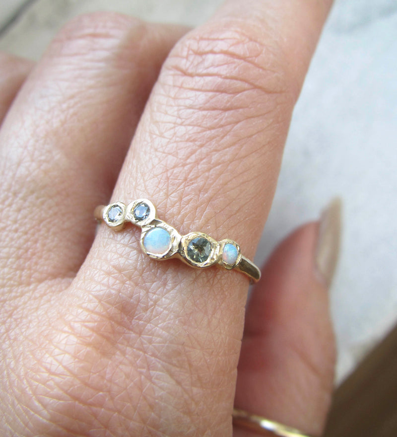 Gold Effervescence Opal and Green Sapphire Ring on Woman's Hand.
