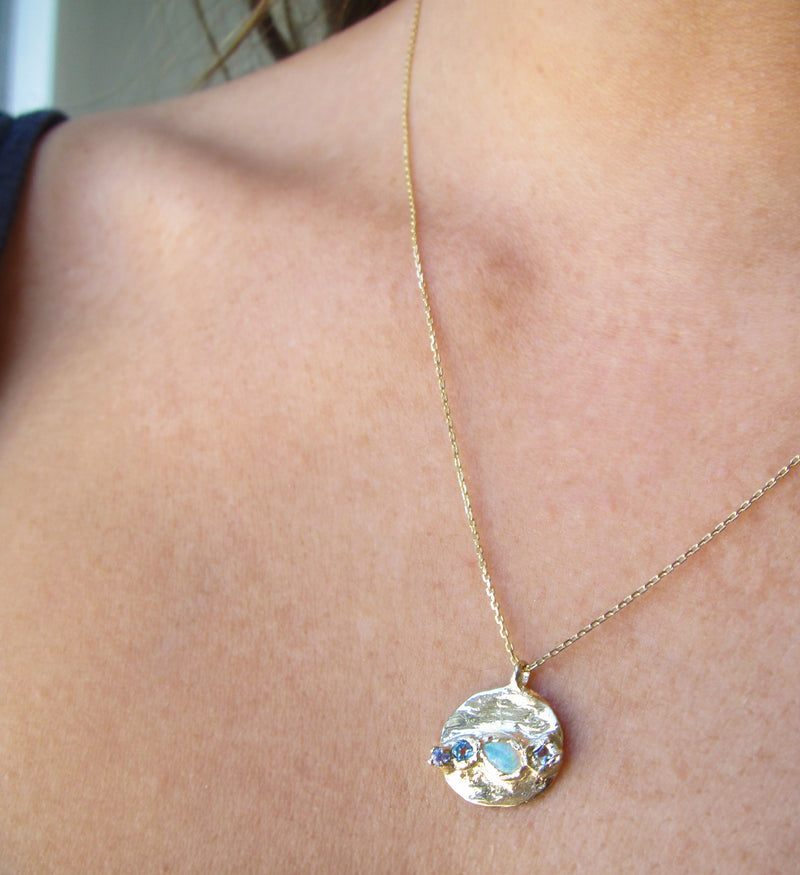 Medallion mermaid necklace on woman's neck.