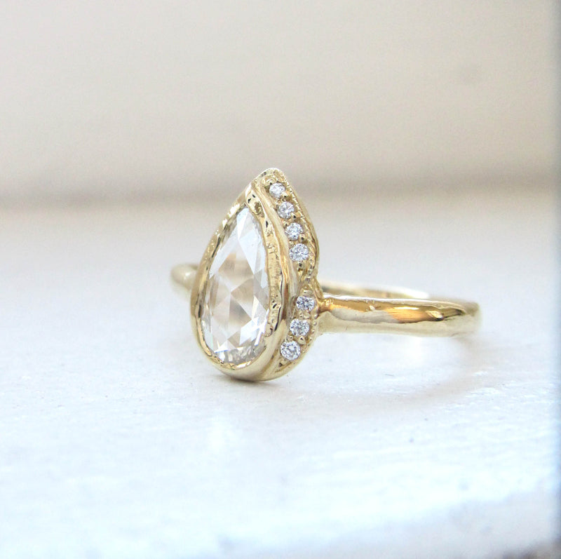 Pear-shaped Raindrop Rosecut Diamond Ring with White Round Brilliant Diamonds.
