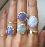 Blue Lace Agate  Hidden Cove Gold Ring on Woman's Hand next to more Hidden Cove Gold Rings.