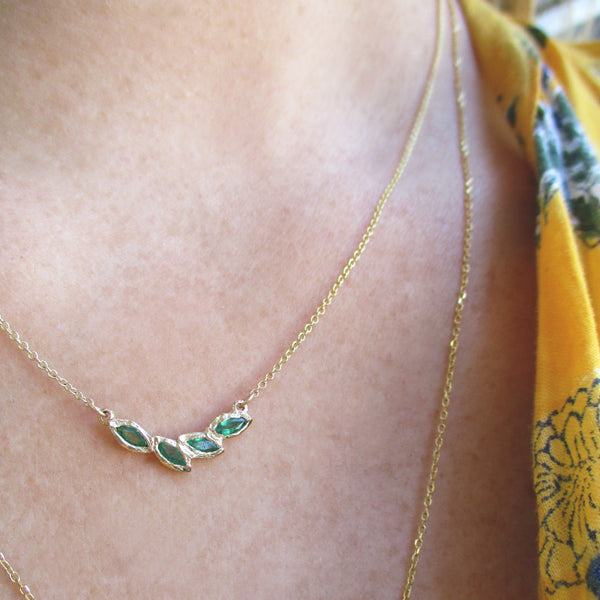 14k Petal Emerald Necklace on woman's neck.