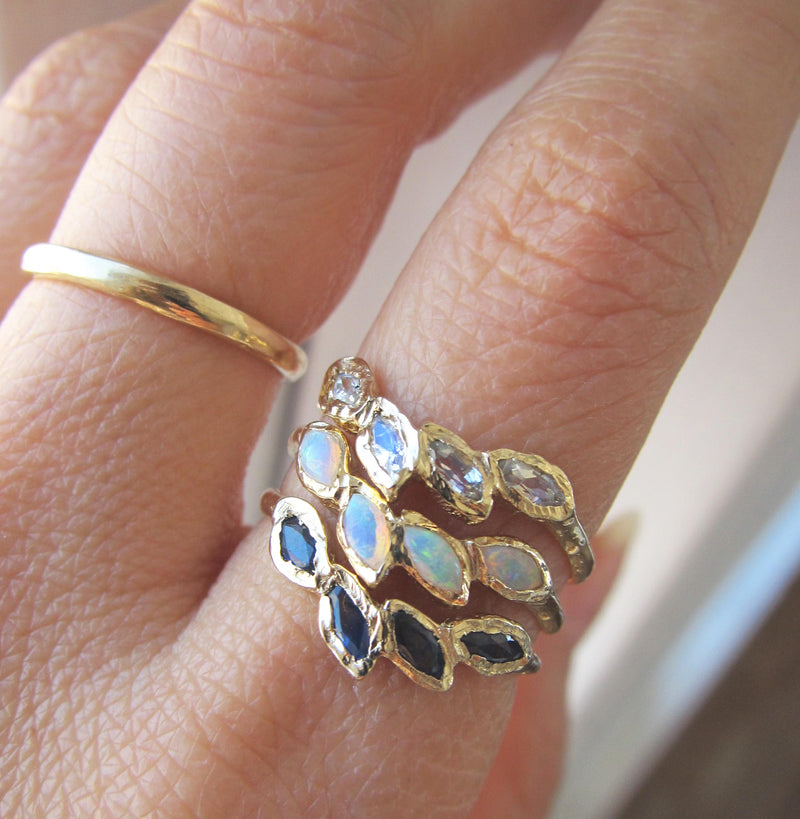 14K Yellow Gold Sapphire Ring Next to Opal and Petal Moonstone Rings. 