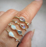 Marina mermaid ring with blue topaz, opal and aquamarine on woman's hand as part of collection.