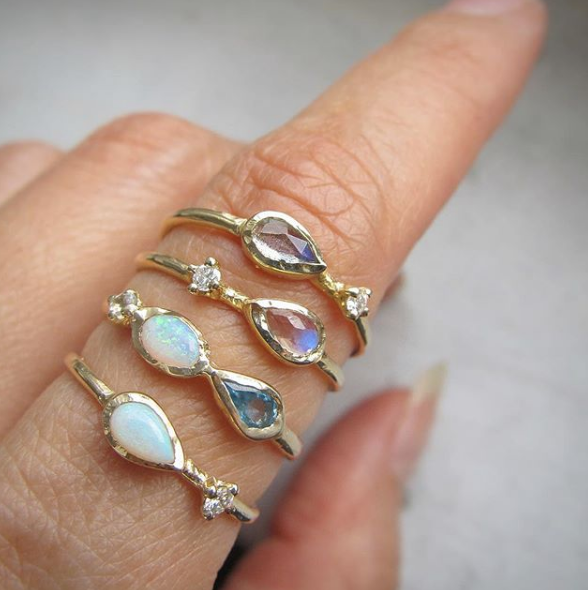 Marina mermaid ring with blue topaz, opal and aquamarine on woman's hand as part of collection.