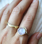 Middle cove moonstone ring with a strip of white round brilliant diamonds on hand.
