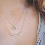Tauri Diamond Necklace made with seven white round brilliant diamonds on woman's neck.