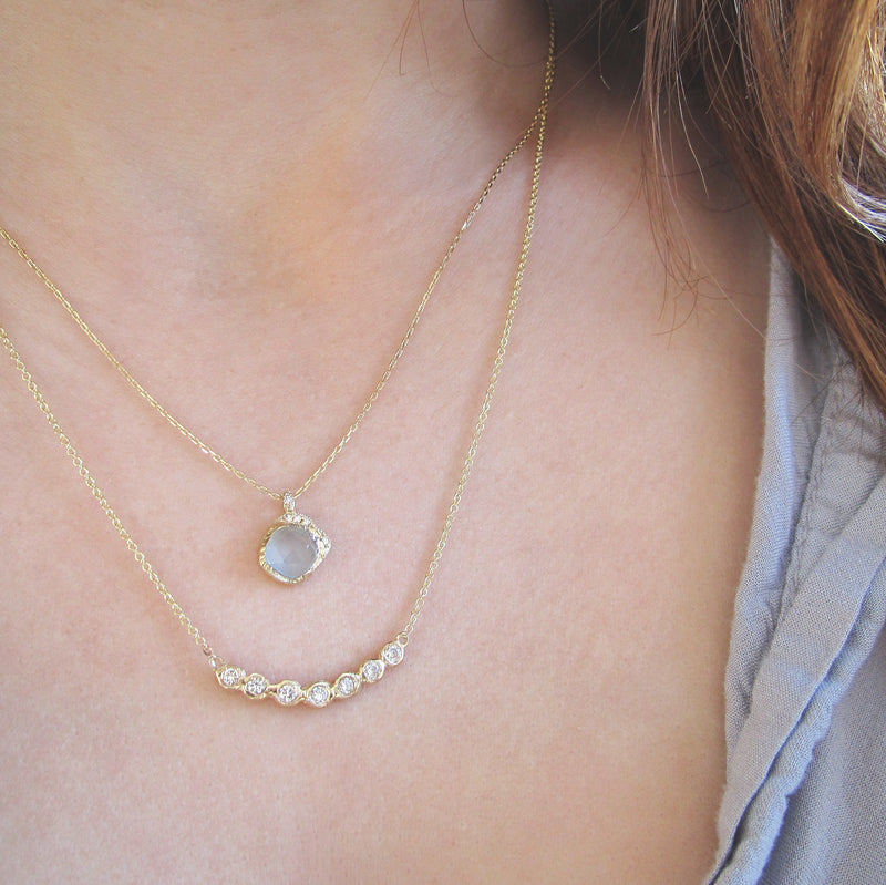 Tauri Diamond Necklace made with seven white round brilliant diamonds on woman's neck.