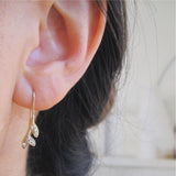Sway Earrings with White Round Brilliant Diamonds on Woman's Ear.