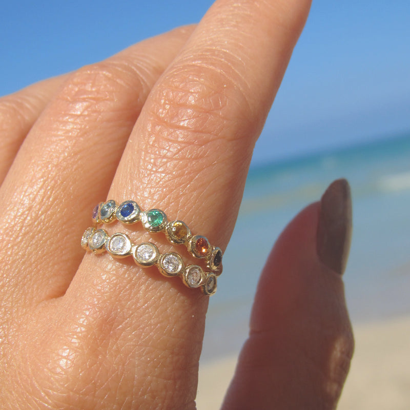Tauri diamond ring with seven white round brilliant diamonds on woman's hand.