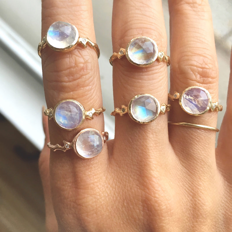 6 Gold moonstone rings on woman's hand. 
