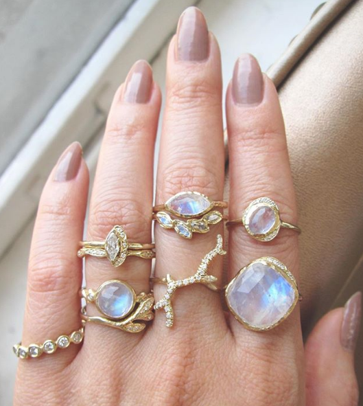 Gold moonstone rings from collection on woman's hand. 