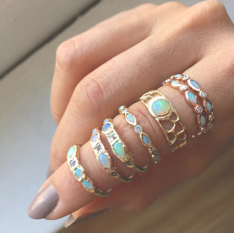 Opal Eternity Rings with opal and mermaids on woman's index finger.