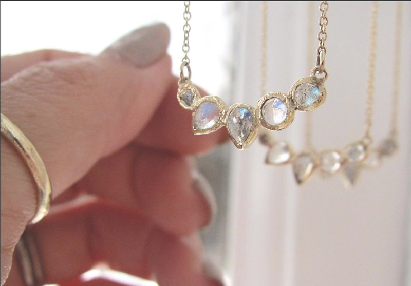 Grey diamond, labradorite and rainbow moonstone gold necklaces hanging. 