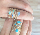 Gold Opal Rings on woman's hands.