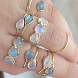 14k yellow gold rings with opal and moonstone on woman's hand.