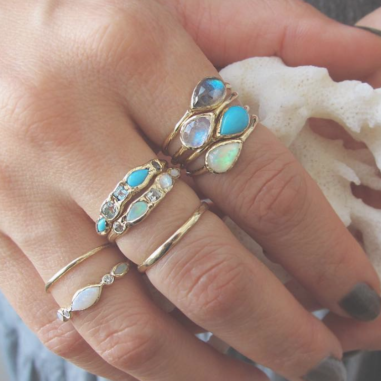 14k yellow gold rings with opal and moonstone on woman's left hand.