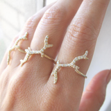 3 Gold Branch rings with diamonds on woman's hand.