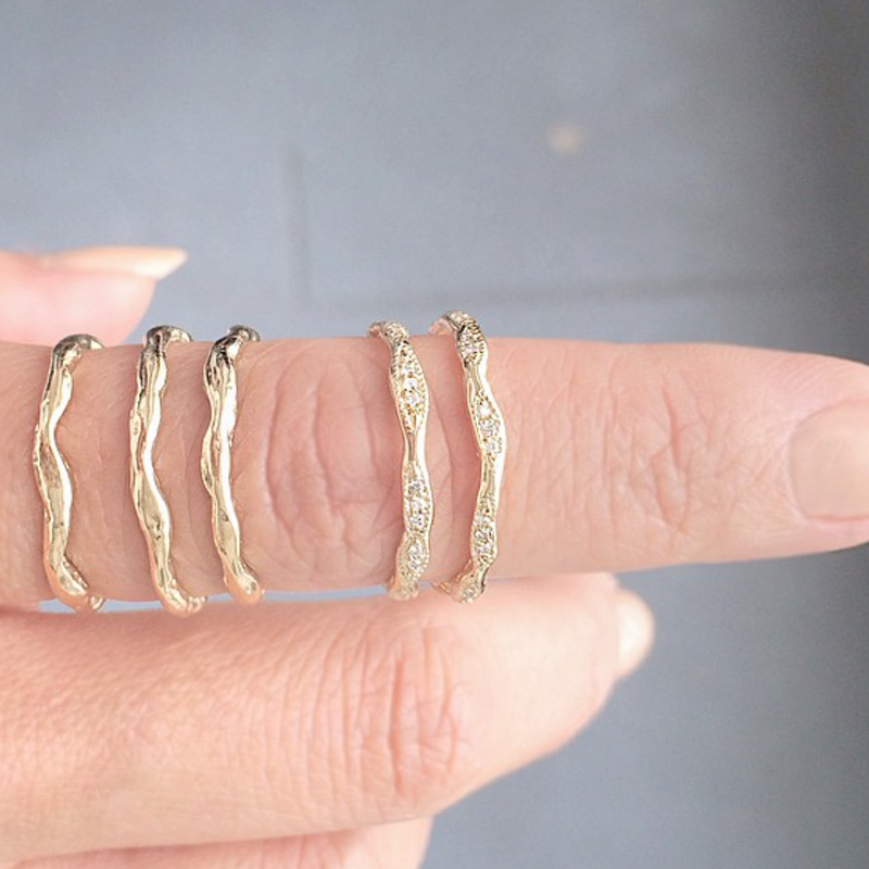 5 14K Gold Wave Eternity Rings on Woman's hand.