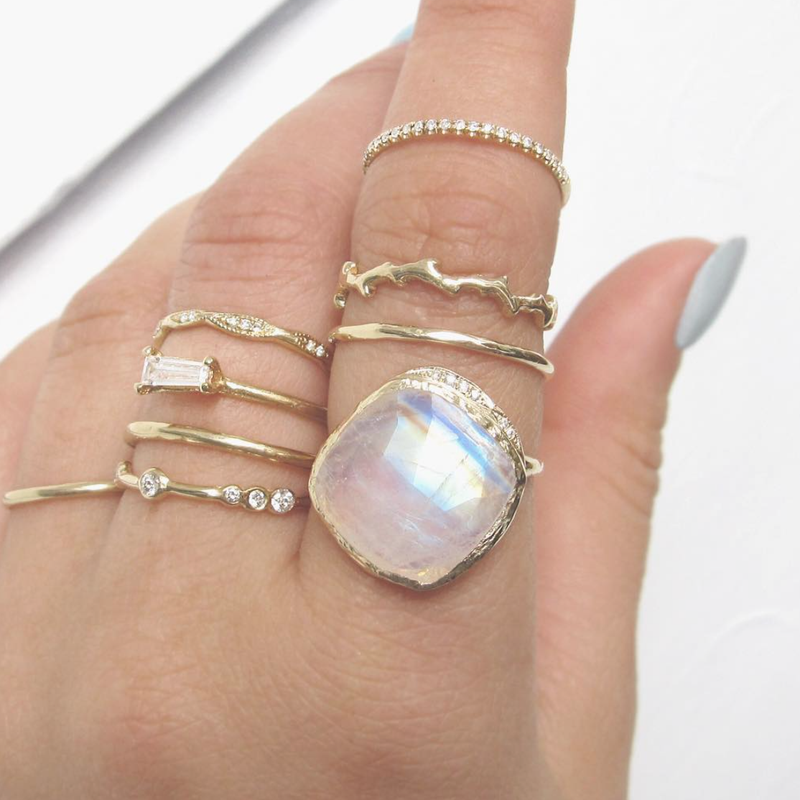 Moonstone Yellow Gold Rings on woman's left hand.