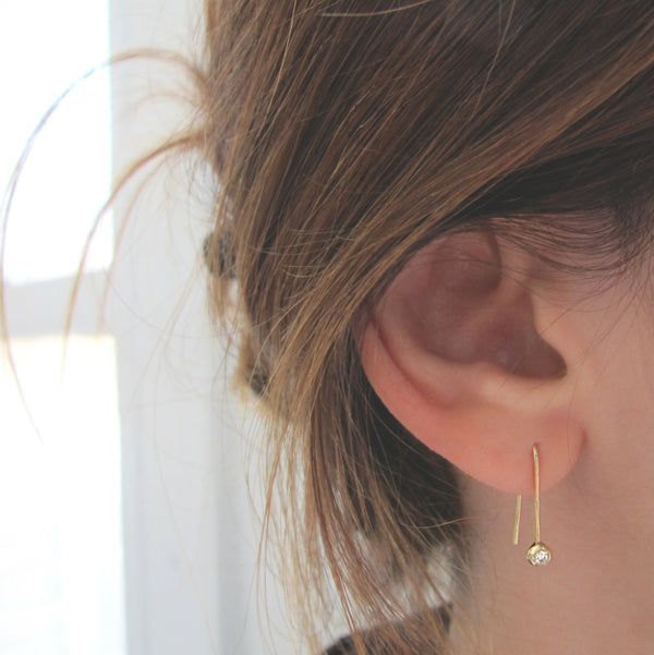 14K Yellow gold Stardust Diamond Earrings on woman's ear.