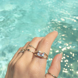 14K Yellow Gold Ring with gemstone on woman's hand by the water. 